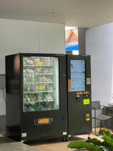 Há uma máquina de venda automática ao lado de um refrigerador de bebidas. em Hatyai Signature Hotel em Hat Yai