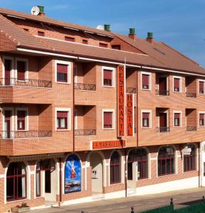 a large red brick building with a sign on it at Hostal La Maravillosa in Valderas