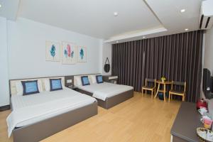 una camera d'albergo con due letti e un tavolo di King House Hotel a Móng Cái
