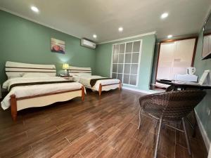 1 dormitorio con 2 camas, mesa y sillas en Beach Garden Hotel, en Saipán