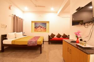 Habitación de hotel con cama y sofá en BHARATHI RESIDHOME en Pondicherry