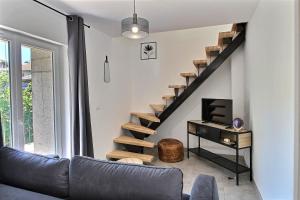 a living room with a couch and a staircase at Apt type 3 en Duplex sur EVIAN les Bains vue lac in Évian-les-Bains