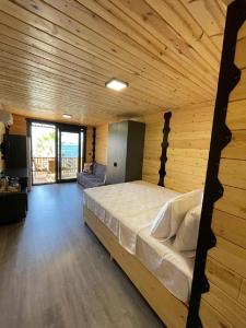 ein Schlafzimmer mit einem großen Bett in einem Holzzimmer in der Unterkunft Bitez Tiny House & Beach in Bodrum City