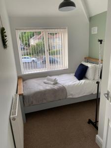 a small bedroom with a bed and a window at Springfield Retreat in Risca