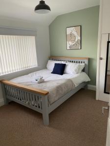 a bedroom with a bed with white sheets and blue pillows at Springfield Retreat in Risca