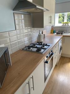 a kitchen with a stove top oven sitting on a counter at Springfield Retreat in Risca +7 photos