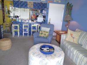 a living room with a couch and a table at A18 Parrot Escape - OCEAN VIEW! There is nothing quite like a Carolina sunrise viewed from your private oceanfront deck condo in Carolina Beach