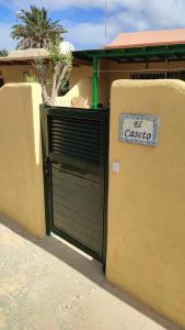 une porte de garage verte avec un panneau indiquant ele casota dans l'établissement El Caseto, à Costa Calma