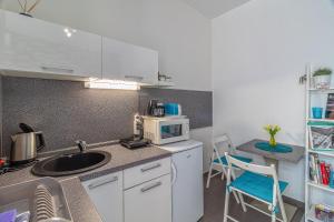 una pequeña cocina con fregadero y microondas en Bratislava -apartment near the City center with a balcony en Bratislava