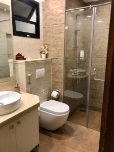 een badkamer met een toilet en een glazen douche bij Studio in Riviera Sublime in Siolim