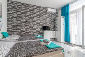 een slaapkamer met 2 bedden en een bakstenen muur bij Bratislava -apartment near the City center with a balcony in Bratislava