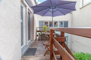 a patio with a table and an umbrella on a balcony at Bratislava -apartment near the City center with a balcony in Bratislava