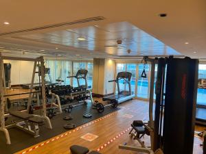 um ginásio num navio de cruzeiro com máquinas de rolamento em One bedroom apartment with pool & gym near Marina em Dubai