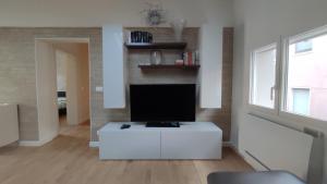 a living room with a flat screen tv on a white cabinet at Casa Vacanze "Machí" in Senigallia