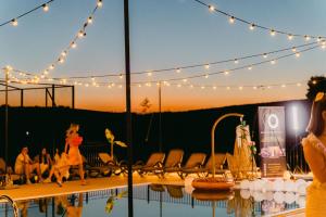 a group of people standing around a swimming pool with lights at Metropol in Baile Felix
