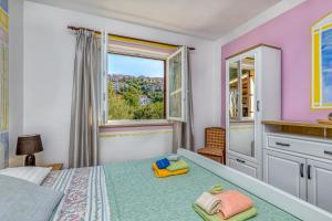 um quarto com uma cama e uma janela em Apartments Vivijana em Rabac