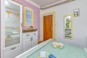 um quarto para crianças com paredes cor-de-rosa e uma área recreativa em Apartments Vivijana em Rabac
