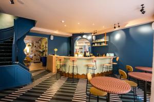 a restaurant with blue walls and tables and stools at P6 Antwerp in Antwerp