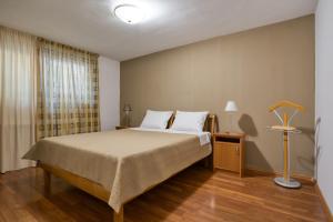 ein Schlafzimmer mit einem Bett und einer Lampe auf einem Holzboden in der Unterkunft Apartman Marija LUX in Sveti Stefan