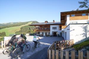 a group of people riding bikes in front of a building at Landhaus Saalbach - Joker card included in summer in Saalbach-Hinterglemm +197 photos