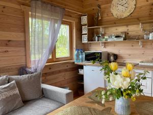 sala de estar con mesa y reloj en la pared en Ragaciema Skadiņi, en Ragaciems