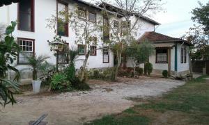 a white house with trees in front of it at Pouso Realeza in Tiradentes