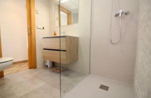 サンタ・ポラにあるLujoso apartamento en 1ª línea recién reformadoのバスルーム(ガラス張りのシャワー、シンク付)