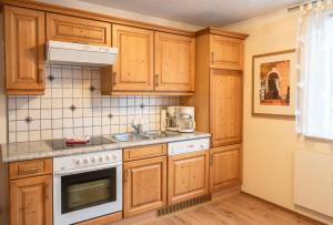 a kitchen with wooden cabinets and a sink at Heimeliges Apartment in den Bergen in Bad Kleinkirchheim