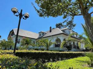 a large white house with a street light in front of it at Laguna Hotel in Ureki