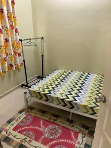 uma cama num quarto com um tapete no chão em Desa Hana Homestay em Kuala Terengganu