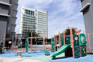 un parque infantil frente a un edificio alto en HOT! Niki Adina - City Centre - Astro - MSU - WiFi, en Shah Alam