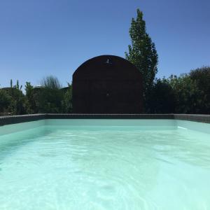 uma grande piscina de água azul com um edifício ao fundo em Orti di Capalbio em Capalbio