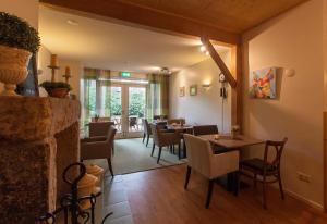a dining room with tables and chairs and a fireplace at Hoeve Springendal in Ootmarsum