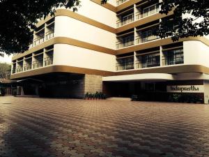 a large building with a brick courtyard in front of it at Hotel Indraprastha in Palakkad