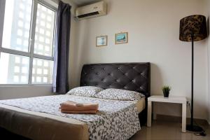 Schlafzimmer mit einem Bett mit einem schwarzen Kopfteil und einem Fenster in der Unterkunft HOT! Niki Menara U2 - City Centre - Aeon Mall - WiFi Netflix - MSU in Shah Alam