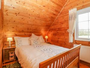 ein Schlafzimmer mit einem Bett in einem Blockhaus in der Unterkunft Orchard Lodge in Wellington