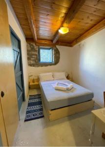 a bedroom with a bed in a room with a wooden ceiling at Pappou's Traditional Cottage at Epano Elounda in Elounda