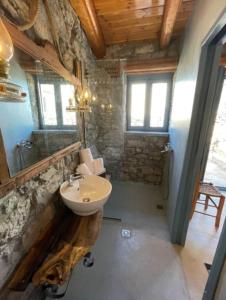 La salle de bains est pourvue d'un lavabo et d'un miroir. dans l'établissement Pappou's Traditional Cottage at Epano Elounda, à Elounda