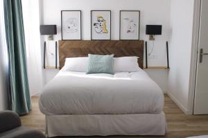 - une chambre avec un grand lit et 4 photos sur le mur dans l'établissement LA TOUR AUX CRABES près de la plage, à Dieppe