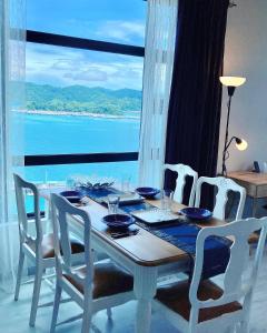 a dining room table with a view of the ocean at Mango House-PanoramaSeaView I Biggest unit I Wifi I WaterFilter I Latex I Gym-JQ in Kota Kinabalu