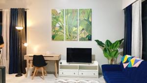 ein Wohnzimmer mit einem blauen Sofa und einem TV in der Unterkunft Mango House-PanoramaSeaView I Biggest unit I Wifi I WaterFilter I Latex I Gym-JQ in Kota Kinabalu