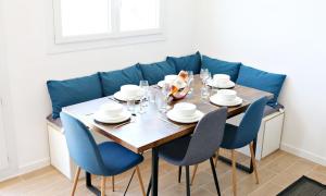uma mesa de jantar com cadeiras e um sofá azul em Air'BABY - 1 à 6 PERSONNES - Colomiers Centre em Colomiers