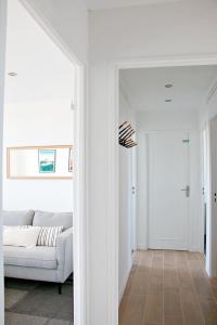 ein Wohnzimmer mit einer weißen Couch und einer Tür in der Unterkunft T4 Pro Groupes - 5min Airbus - 6pers - Parking in Colomiers + 13 Fotos