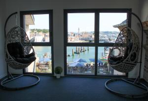 a room with two hanging chairs in front of a window at LA TOUR AUX CRABES près de la plage in Dieppe