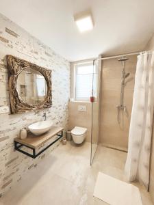 een badkamer met een wastafel, een toilet en een spiegel bij Apartman i Studio Smrikve in Pula