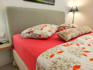 uma cama com duas almofadas e um cobertor vermelho em Lovely luxury apartment Sokratous 133, Kallithea em Atenas