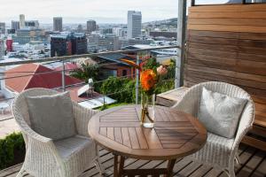 einen Tisch und Stühle auf einem Balkon mit Aussicht in der Unterkunft Upperbloem Guesthouse and Apartments in Kapstadt