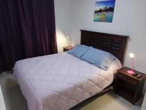 a bedroom with a large white bed with two lamps at Arriendo Diario En La Playa Sector Casino ENJOY in Coquimbo +23 photos