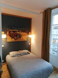 a bedroom with a bed and a painting on the wall at Centre Confolens studios rénovés in Confolens