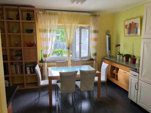 d'une salle à manger avec une table, des chaises et une fenêtre. dans l'établissement Traumhaftes Apartment in Mönchengladbach Ohler, à Mönchengladbach